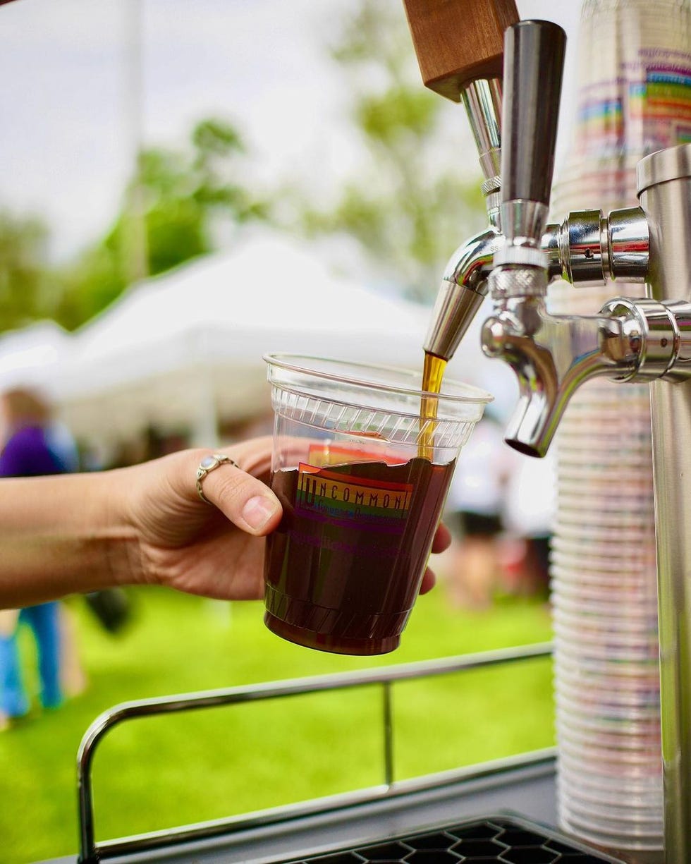 cold brew coffee being poured out of metal canister into plastic cup