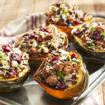 sausage and wild rice stuffed acorn squash halves on a serving tray
