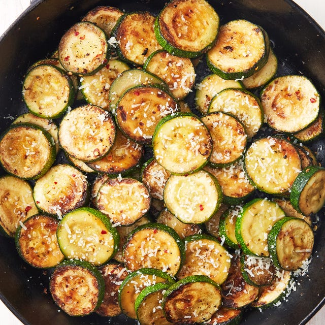 sauteed zucchini in a pan with parmesan