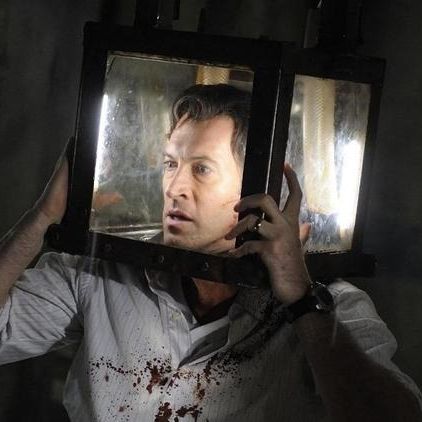 a man's head is trapped in a glass box in a scene from saw v