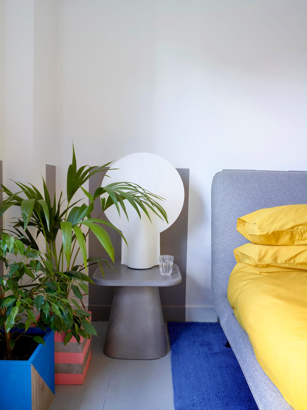 modern bedroom with grey yellow cobalt palette and indoor plants