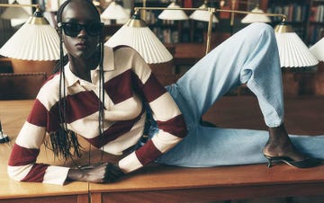 model reclining on a table in a library setting