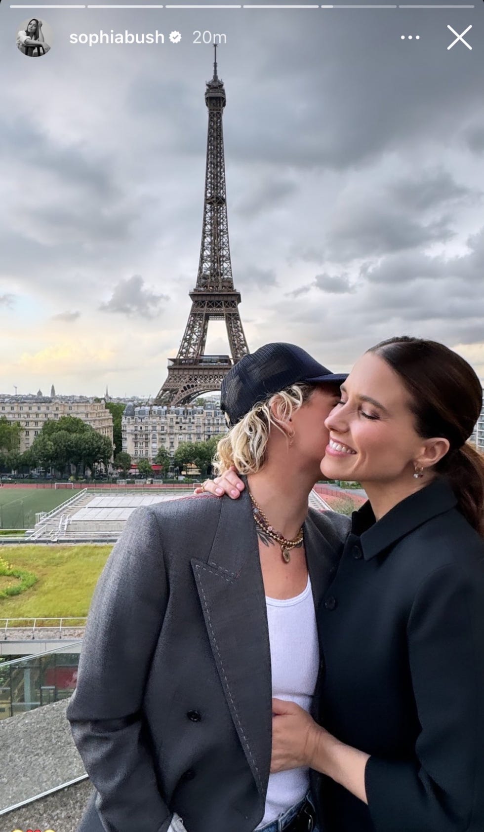 a man and woman kissing in front of the eiffel tower