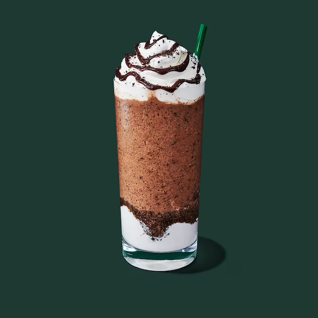a glass of brown liquid with a white substance and a green background