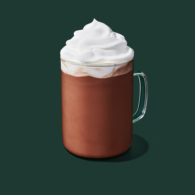 a glass of liquid with a white substance on top