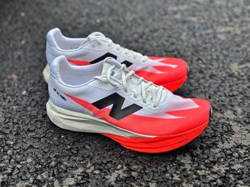 a white and red new balance running shoe on the road
