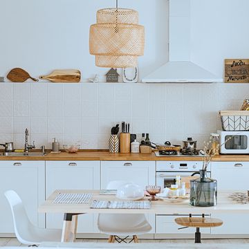 scandinavian style cozy modern kitchen interior with a dining zone, white modern interior, everyday still llife, stay at home coronavirus quarantine, chores