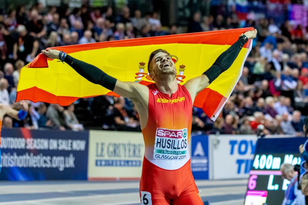 Óscar husillos mira al cielo pleno y feliz celebrando con la bandera de españa su medalla de plata en el euroindoor de torun 2019