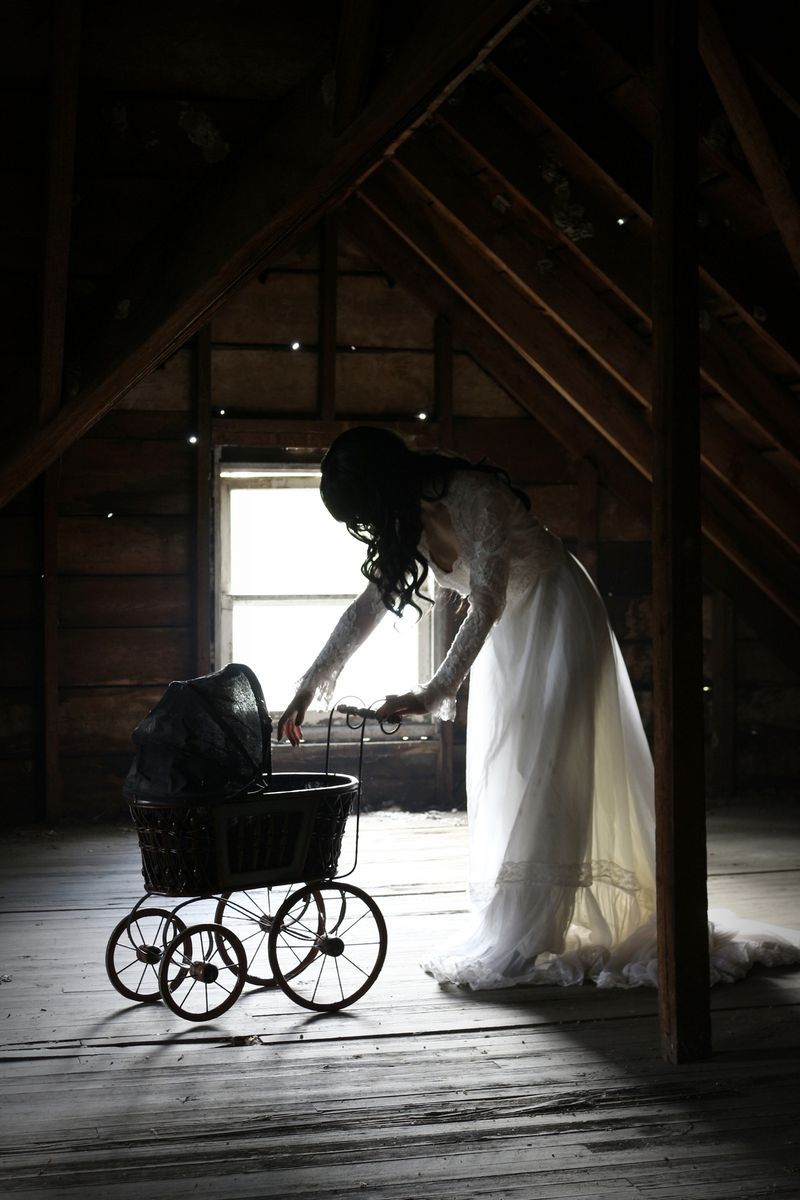 woman with baby carriage in attic