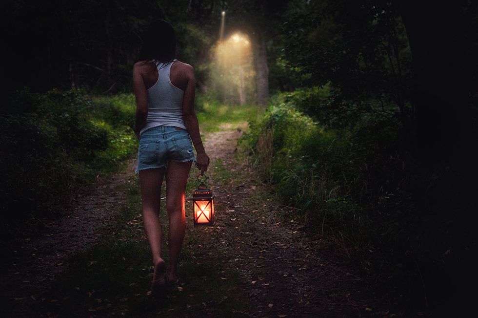 woman walking in the dark with a lantern