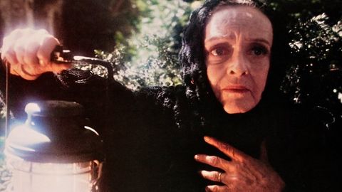 betty davis looks frightened in a scene from watcher in the woods a good housekeeping pick for best scary movies for kids