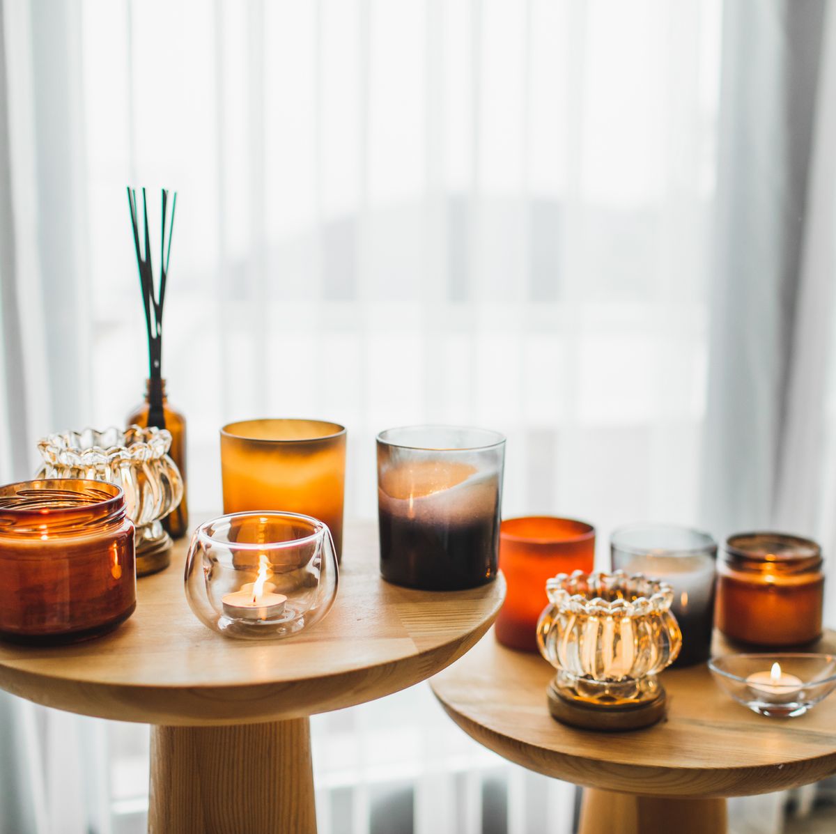 scented candles in different candlelights on wooden table at home