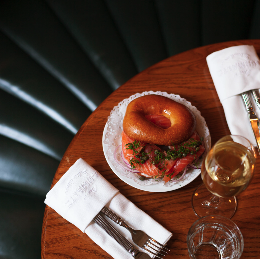 a bagel and a glass of wine on a table