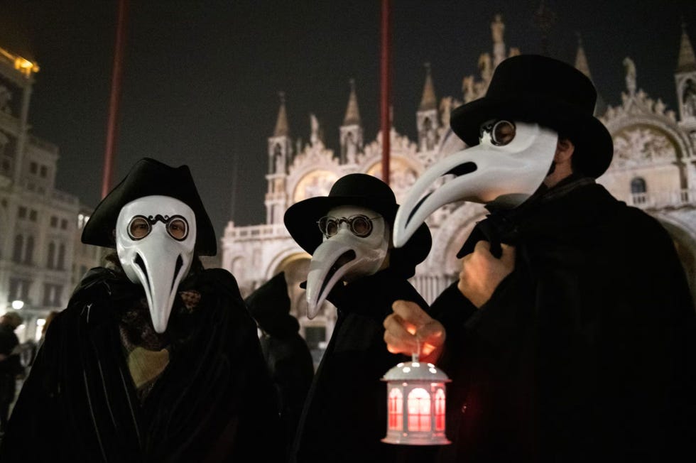 drie feestvierders dragen een pestmasker tijdens het carnaval in venetie