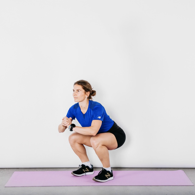 vrouw in shorts en blauw shirtje doet een squat