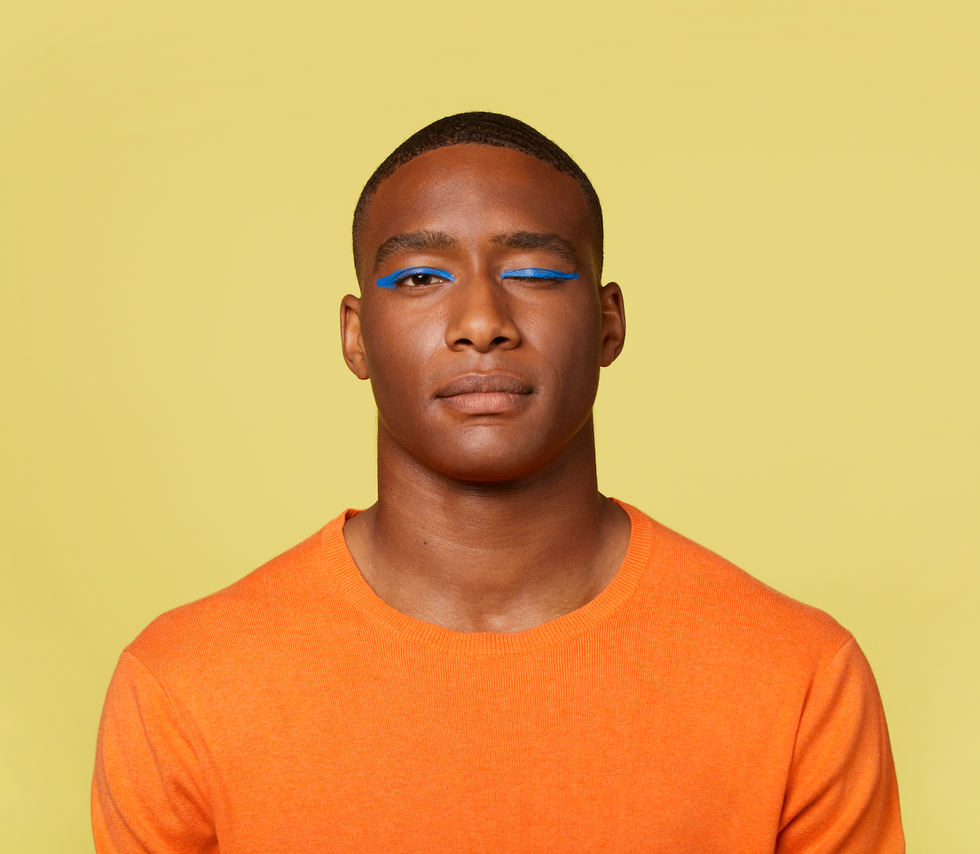 jonge man knipoogt met blauwe eyeliner