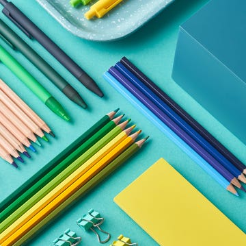 pens, pencils and binder clips on blue background