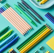 pens, pencils and binder clips on blue background