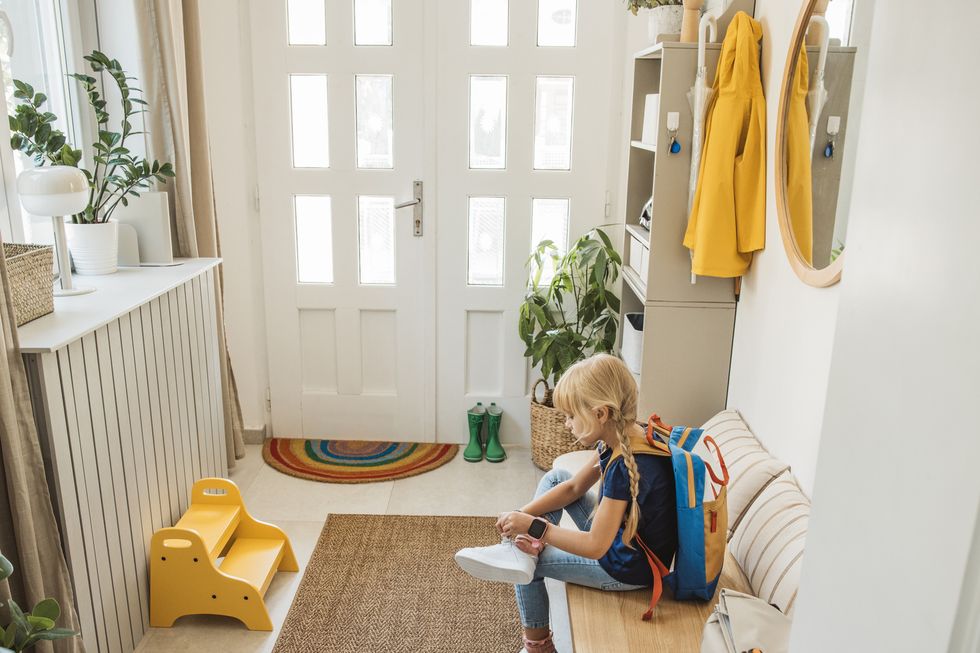 girl preparing for school in entry