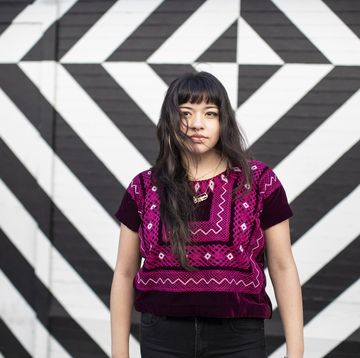 jonge vrouw voor een zwart witte muur met geometrische vormen