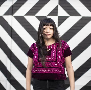 jonge vrouw voor een zwart witte muur met geometrische vormen