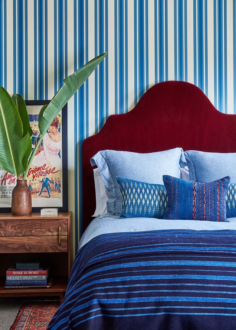 a bed with pillows and linens in indigo hues