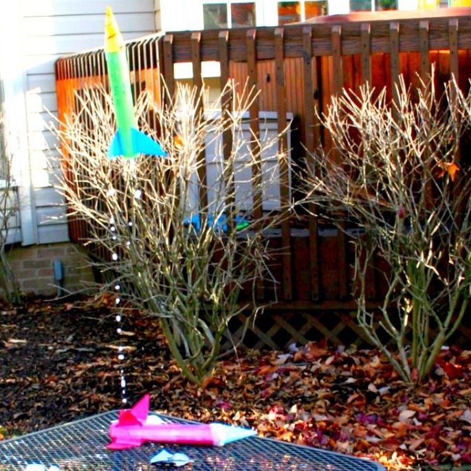 a diy rocket takes off from a table, where another rocket waits, in this science experiment for kids