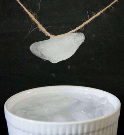 an ice cube is suspended on a string above a bowl of ice in this science experiment for kids