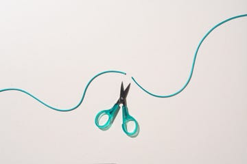 scissors cut a rising curve of rope