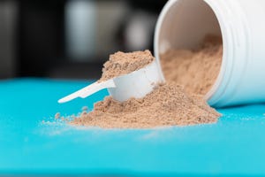 scoop filled with brown or chocolate flavored protein powder