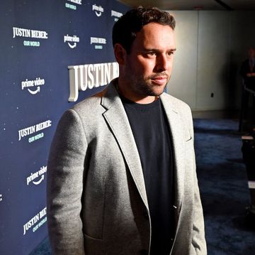 scooter braun looking offscreen at photographers in front of a backdrop