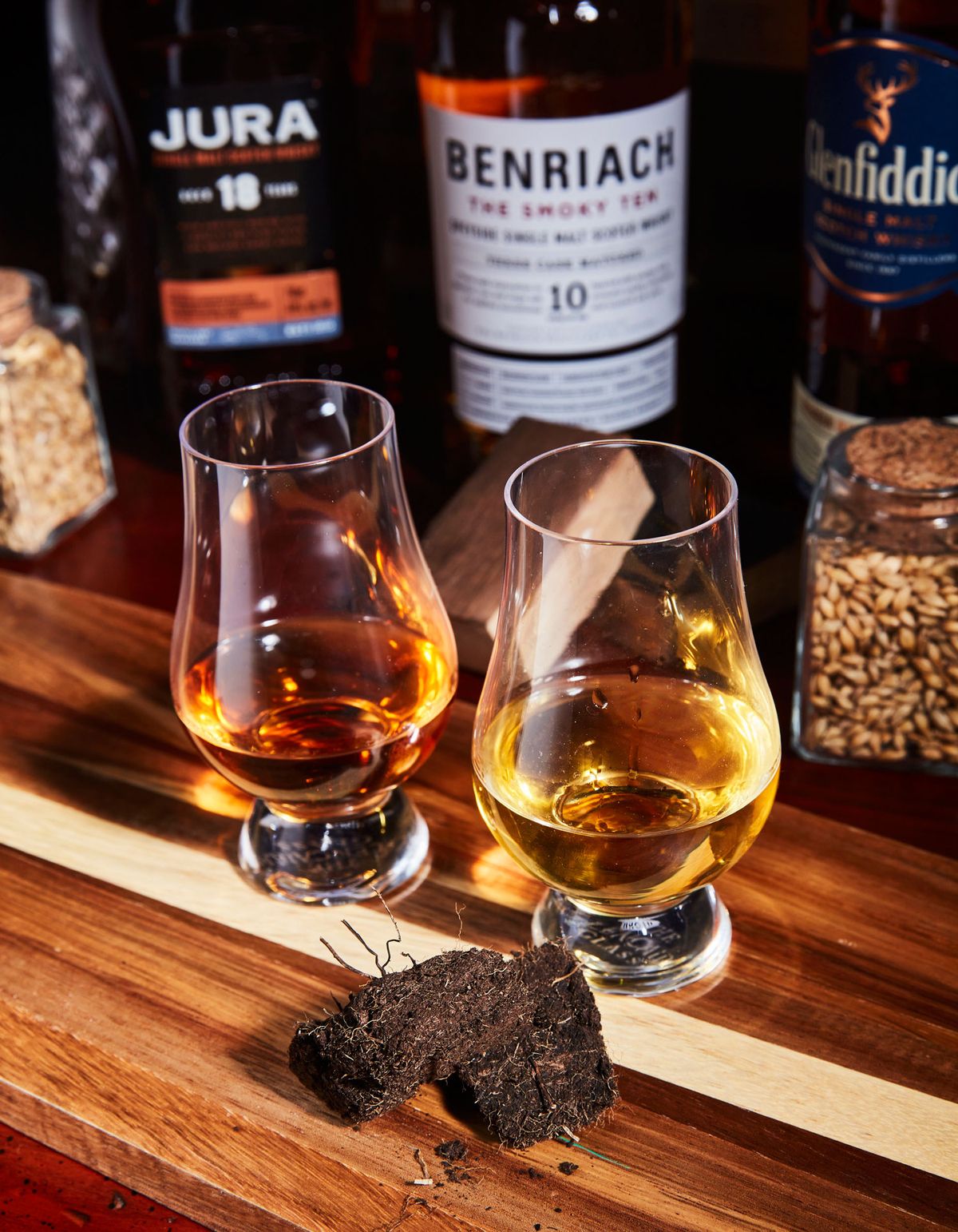 scotch in two glencairn glasses next to peat