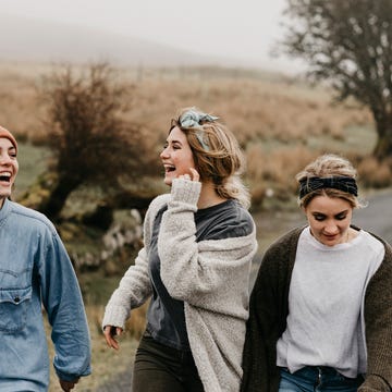 UK, Scotland, Isle of Skye, three happy young woman on a rural road