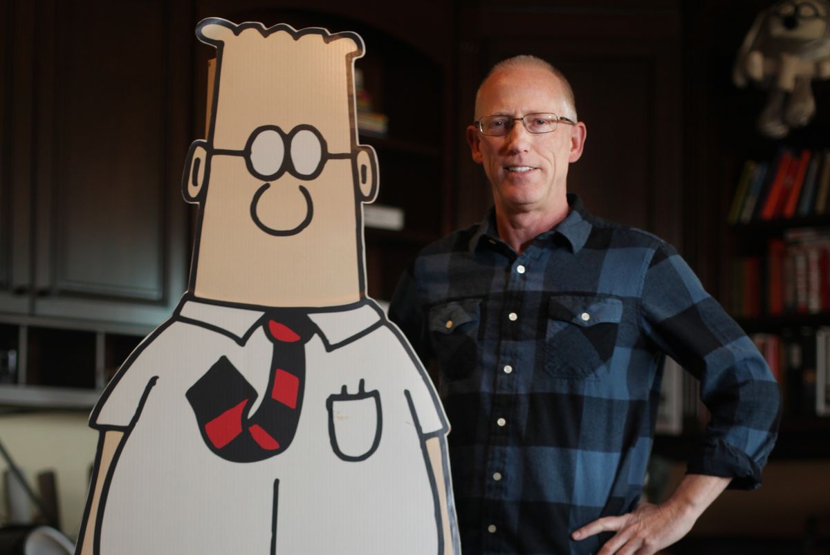 cartoonist scott adams standing with cutout of dilbert comic strip character