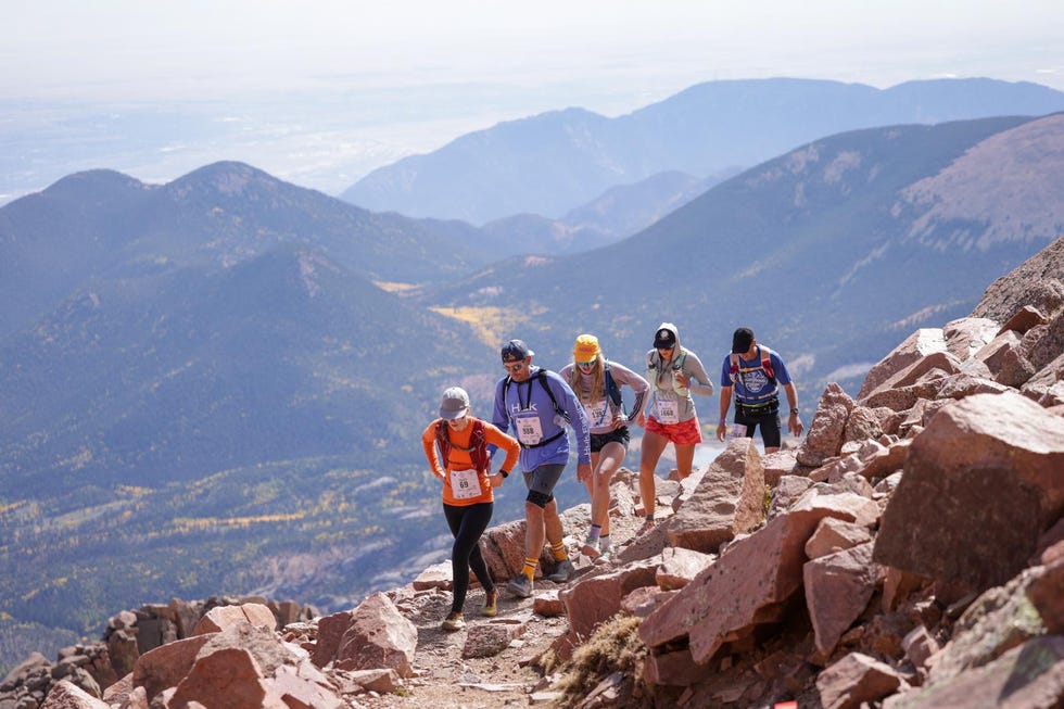 group of runners ascending a rocky mountain trail pikes peak ascent & marathon