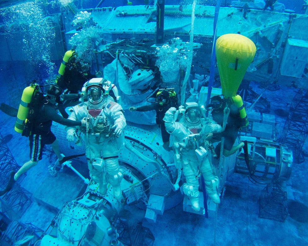 NASAastronaut Scott Tingle rechts behoort tot degenen die zijn geslecteerd voor het trainingsprogramma voor de Artemismissies Op de foto bereiden hij en collegaastronaut Steve Swanson zich in het Neutral Buoyancy Laboratory nabij het Johnson Space Center van de NASA in Houston Texas voor op het maken van ruimtewandelingen