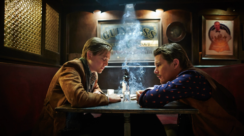 scene from movie predestination, two men sit at a table in a darkly lit bar