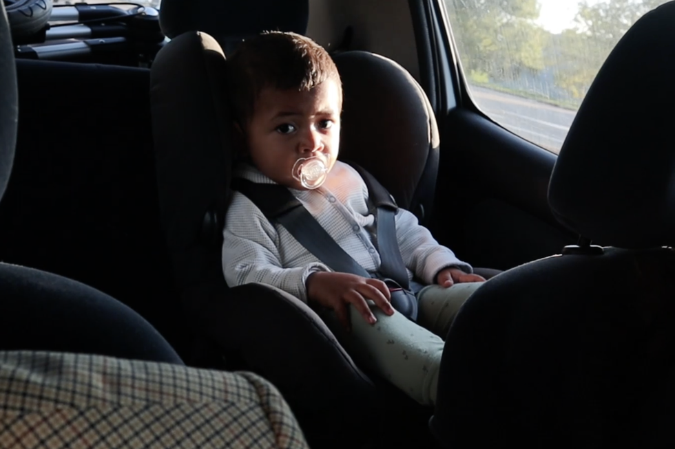 Car seat, Head restraint, Vehicle, Car, Child, Sitting, Car seat cover, Auto part, Family car, Vehicle door, 
