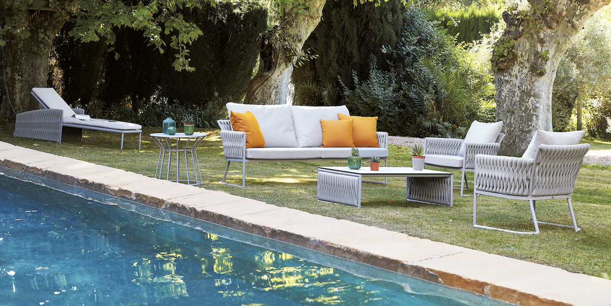 outdoor sofa, chairs, chaise and tables by a pool
