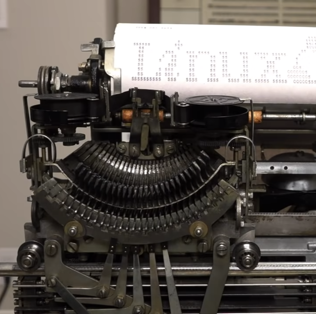an antique teletype machine made of gears and mechanisms, with a printed page emerging from the top that says "linux" in ascii art