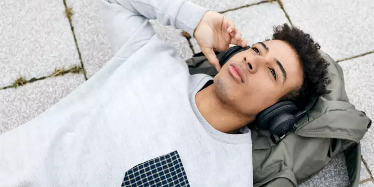 man laying down wearing jbl headphones
