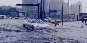 a tesla drives through floodwater in china