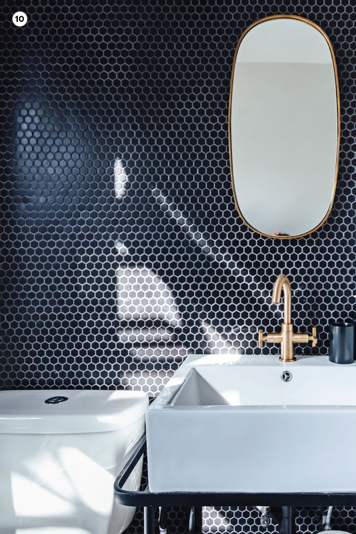 bathroom vanity with blue tile wall and oval mirror