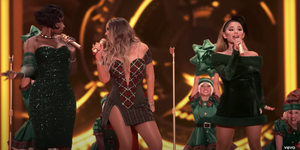 jennifer hudson, mariah carey, and ariana grande dressed in red and green, singing together on stage