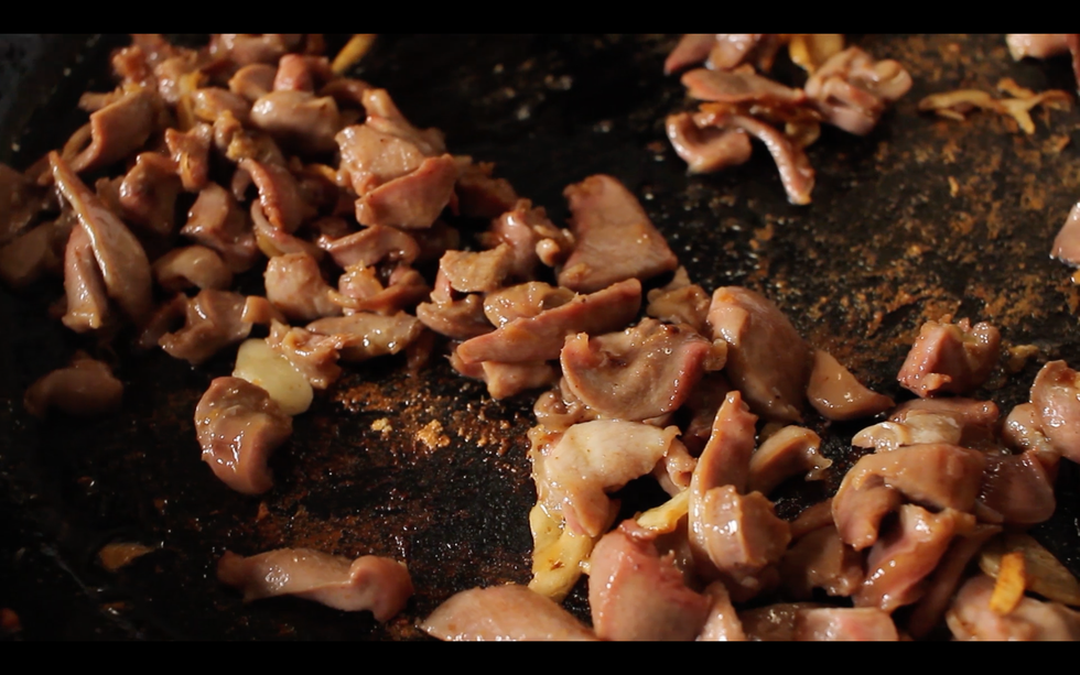 golden bits of chicken gizzards in a cast iron pan