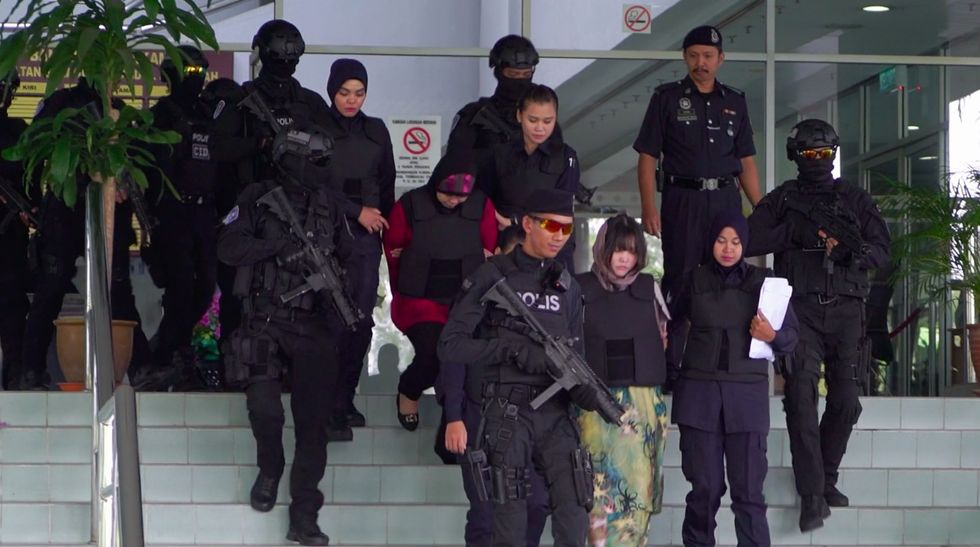 doan thi huong and siti aisyah escorted out of the courthouse by armed guards