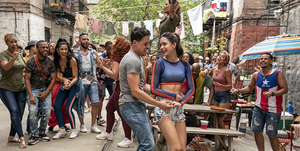 melissa barrera and anthony ramos, two actors, dance in a group in a still from in the heights