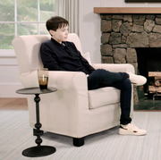 elliot page and oprah winfrey sitting down in two cream colored chairs in front of a fireplace