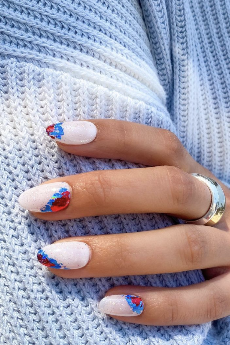 light sparkly painted nails with red and blue colorful foil