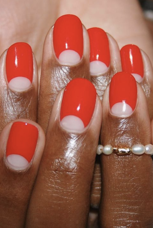 a manicure that features scarlet curves with a pearl ring